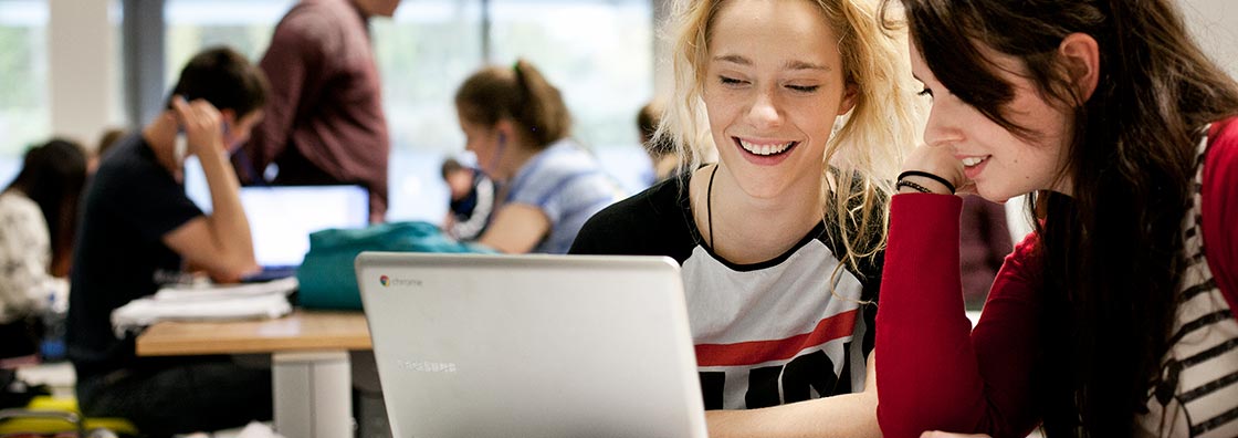 Female students at laptop homepage slider only 1120 x 396 px- Maynooth University