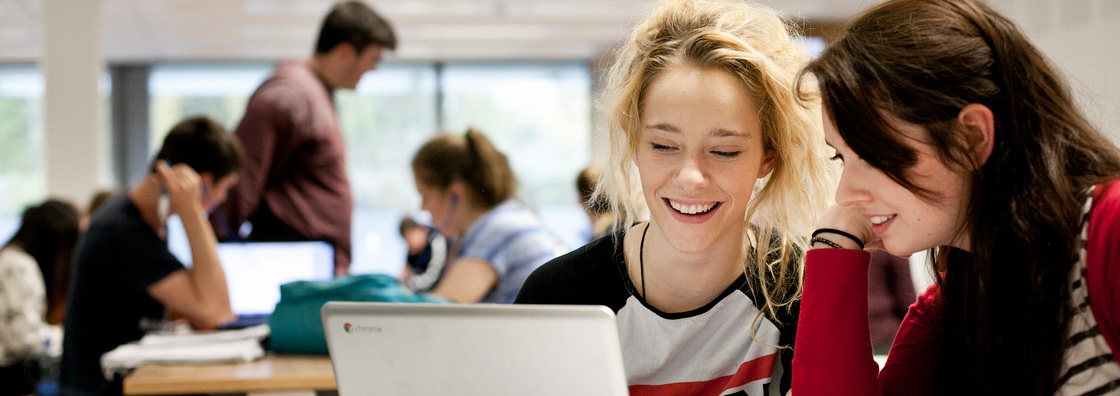 Female students at laptop - Maynooth University