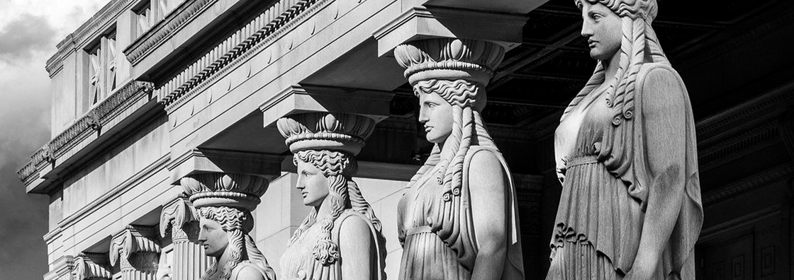 a black and white image of four caryatid statues