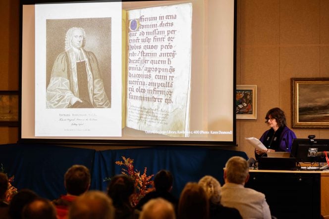 Slide showing a picture of a man in old-fashioned robes and a page of a manuscript