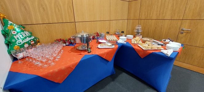 A table with a red tablecloth and mince pies and mulled wine on the table