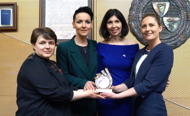 Four women holding an award between them