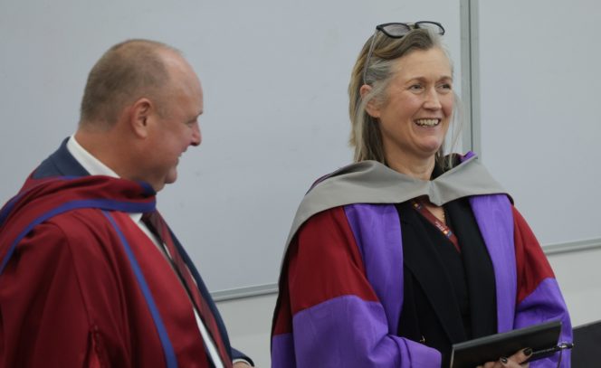 man and woman, looking away from camera, smiling, wine robe, purple robe