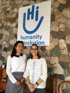 Ana Maria Sanchez Rodriguez standing under Humanity and Inclusion Banner