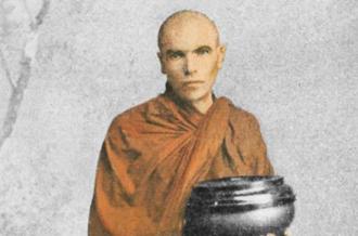 Laurence Carroll in an orange robe, carrying a bowl