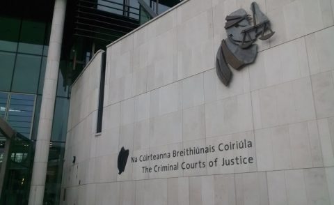 Sign reading The Criminal Courts of Justice with justice symbol