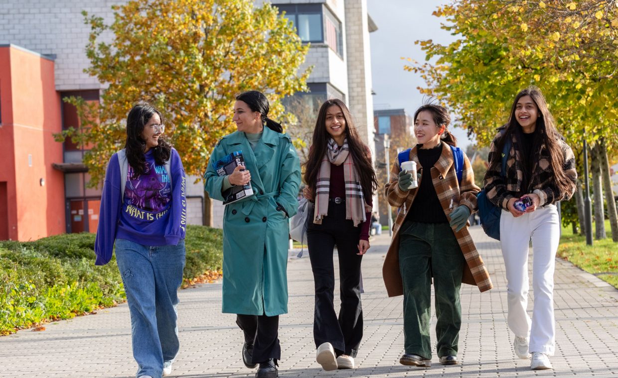 five female students walking together on a sunny day on maynooth campus