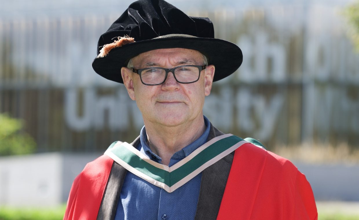 Man wearing a red robe with a black hat