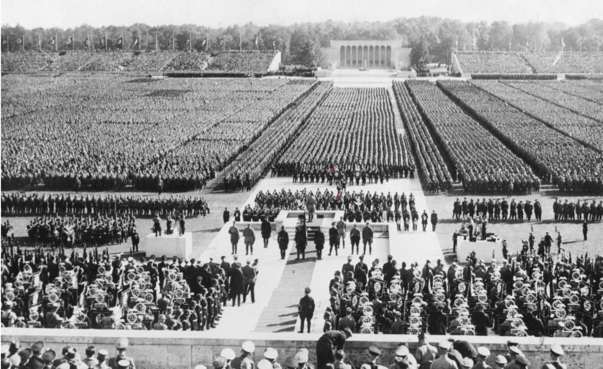 Nazi rally showing rows of people lined up before a podium