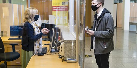 Student in Mask talking to Librarian safely