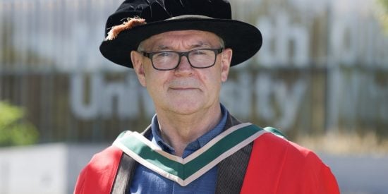 Man wearing a red robe with a black hat