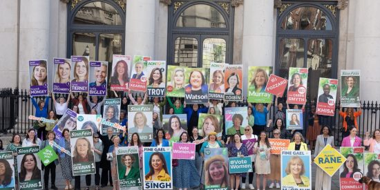 Many women outside Irish government building holding election posters