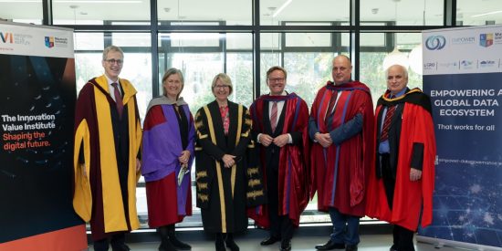 6 people in university gown posing for camera, 2 women, 4 men