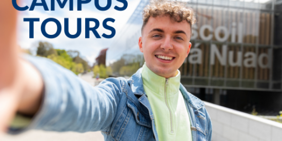 Student ambassador tour guide in front of library smiling