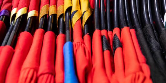 A line of doctoral robes for conferring, hanging up on black hanges