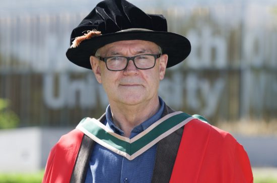 Man wearing a red robe with a black hat